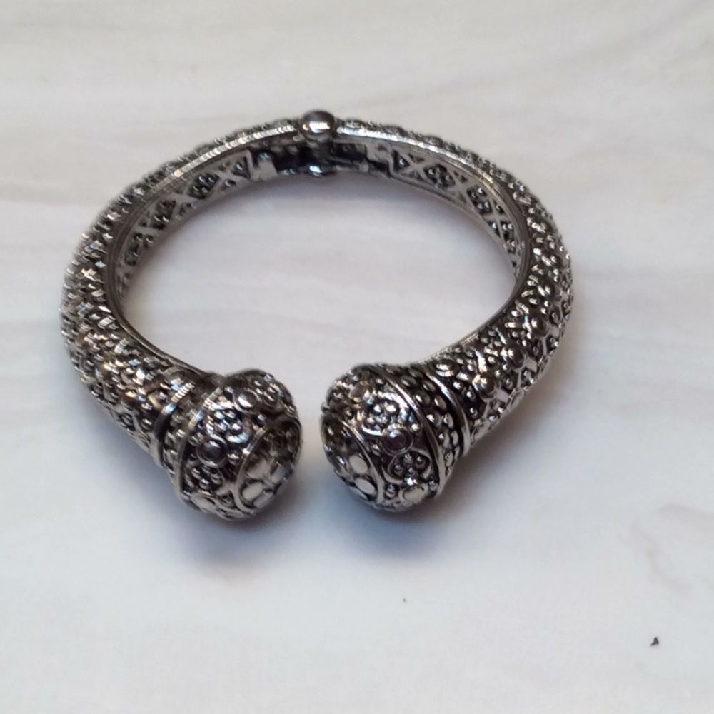Silver tone bangle bracelet with etchings.